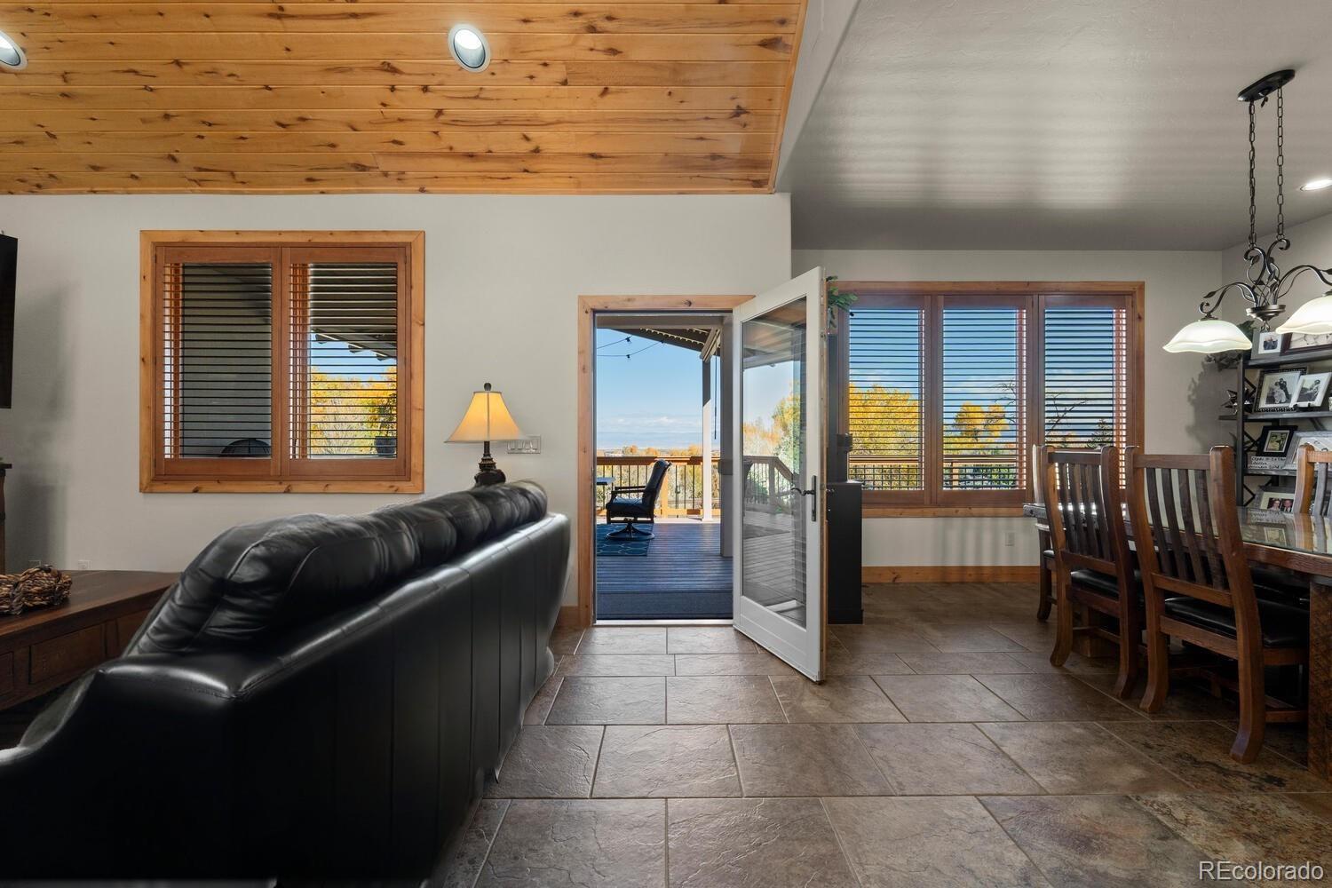 60075 Oak Grove Road Montrose, CO 81403 - Photo 24 of 50 a living room with furniture a dining table and chairs with wooden floor