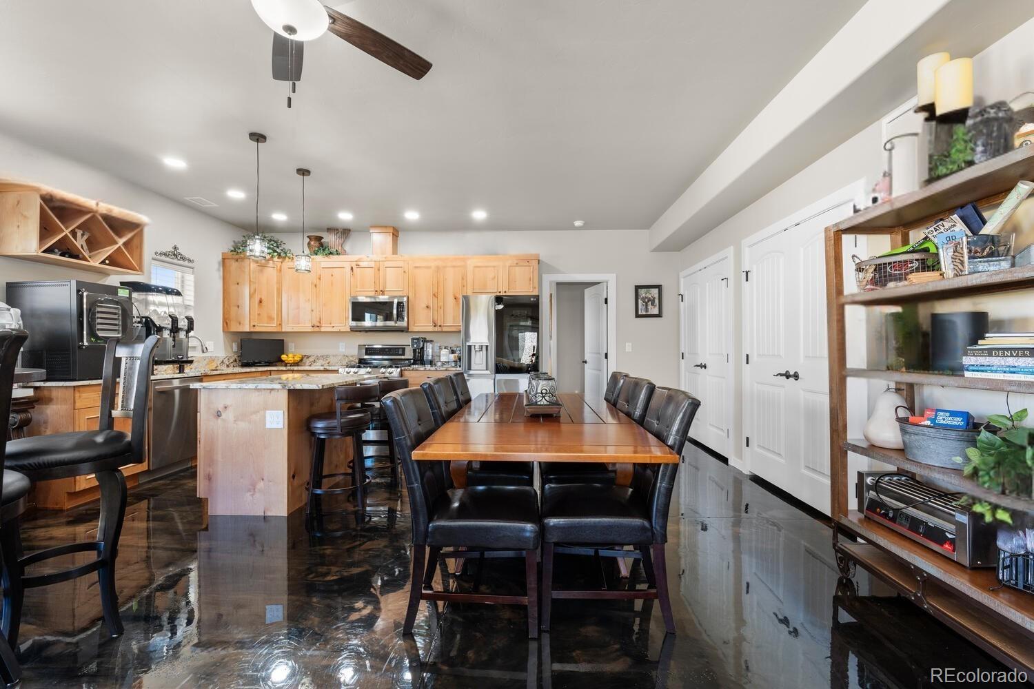60075 Oak Grove Road Montrose, CO 81403 - Photo 32 of 50 a kitchen with stainless steel appliances kitchen island granite countertop a refrigerator a stove a sink a dining table and chairs with wooden floor