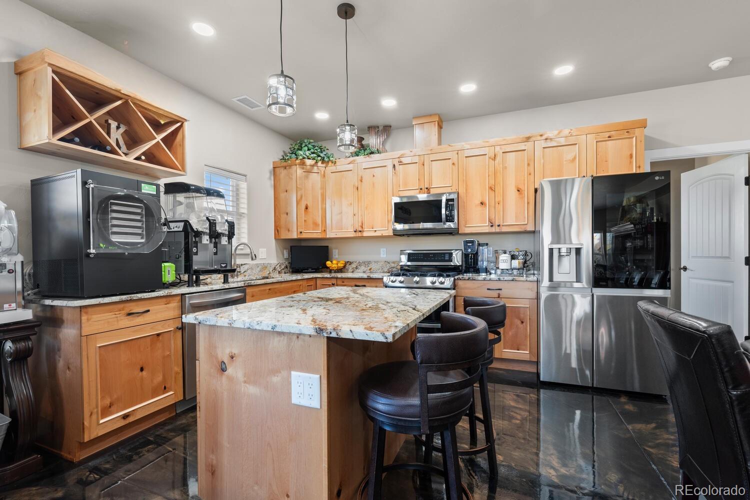 60075 Oak Grove Road Montrose, CO 81403 - Photo 33 of 50 a kitchen with stainless steel appliances kitchen island granite countertop a sink a stove a refrigerator cabinets and chairs