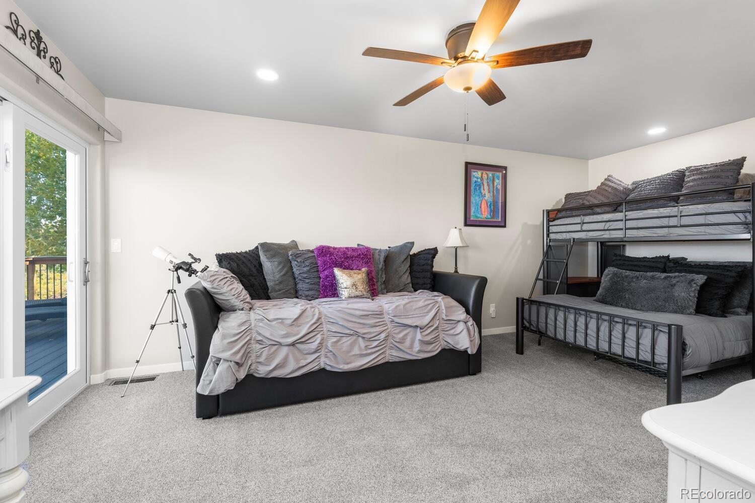 60075 Oak Grove Road Montrose, CO 81403 - Photo 39 of 50 a spacious bedroom with a bed a couch and a chandelier