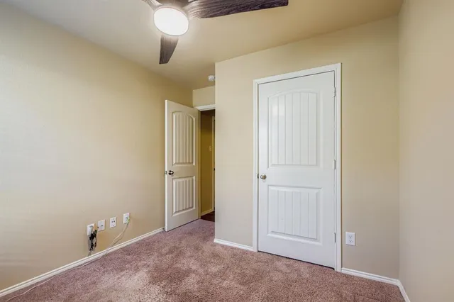 an empty room with closet and fan