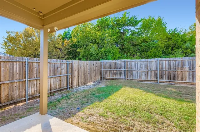 a view of a backyard with a small cabin and wooden fence