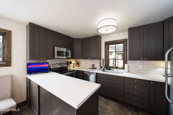 a kitchen with a sink a stove cabinets and wooden floor