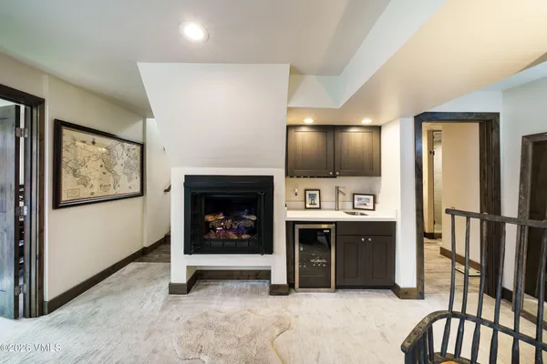 a view of a livingroom with a fireplace and kitchen space
