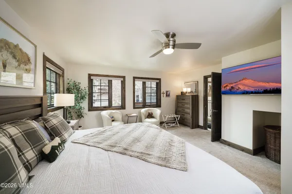 a spacious bedroom with a bed a couch and large window