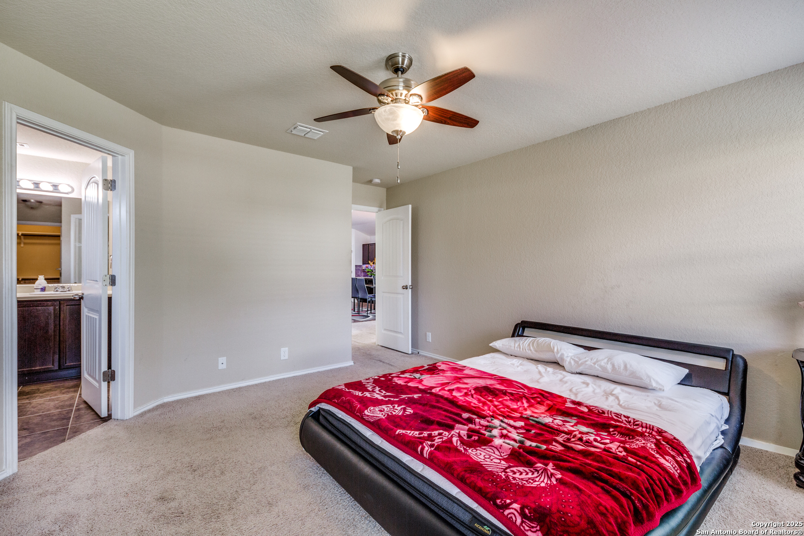 10415 Rhyder Ridge San Antonio, TX 78254 - Photo 13 of 25 a bedroom with a bed and a chandelier