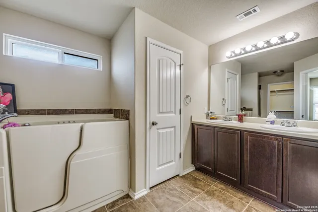 a spacious bathroom with a mirror sink and toilet
