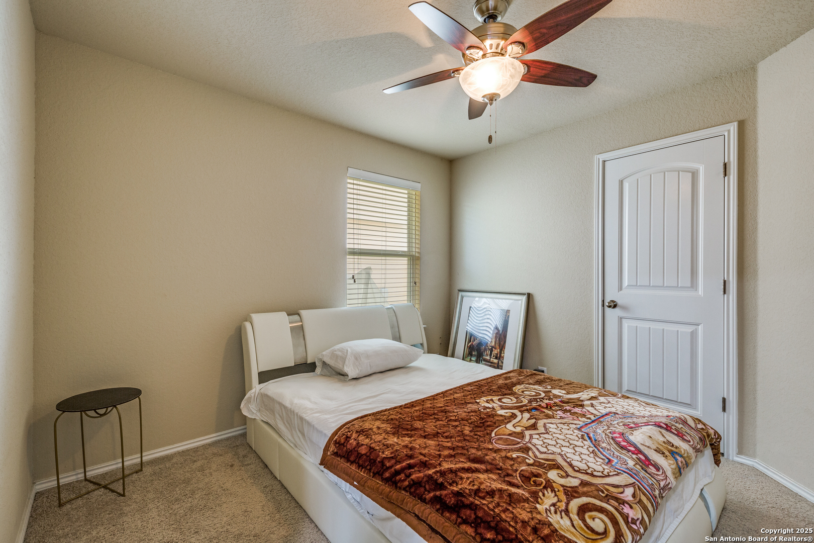 10415 Rhyder Ridge San Antonio, TX 78254 - Photo 22 of 25 a bedroom with a bed and a chandelier
