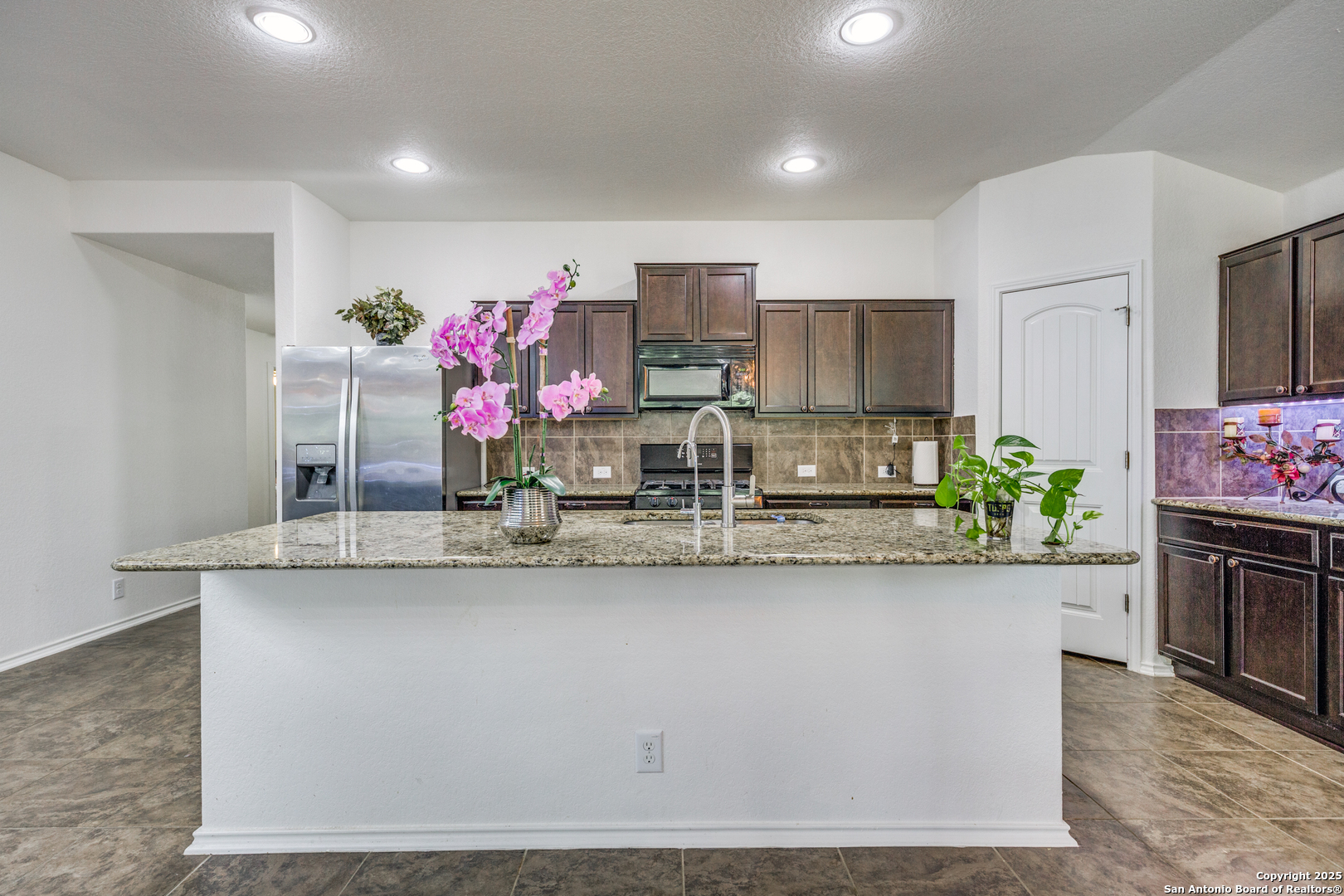 10415 Rhyder Ridge San Antonio, TX 78254 - Photo 4 of 25 a kitchen with stainless steel appliances granite countertop a white cabinets a sink and a counter top
