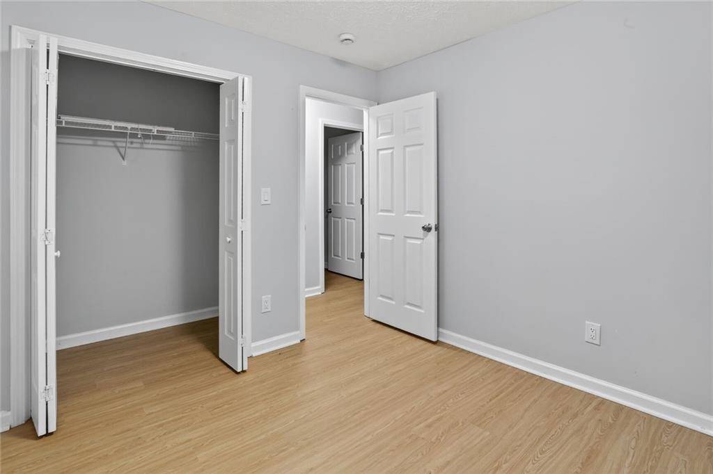 218 Nicki Court Hampton, GA 30228 - Photo 16 of 17 a view of an empty room with wooden floor & closet area