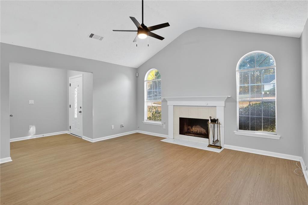 218 Nicki Court Hampton, GA 30228 - Photo 5 of 17 an empty room with windows fireplace and fan
