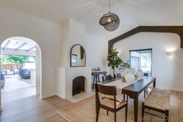 a dining room with furniture a potted plant and a fireplace