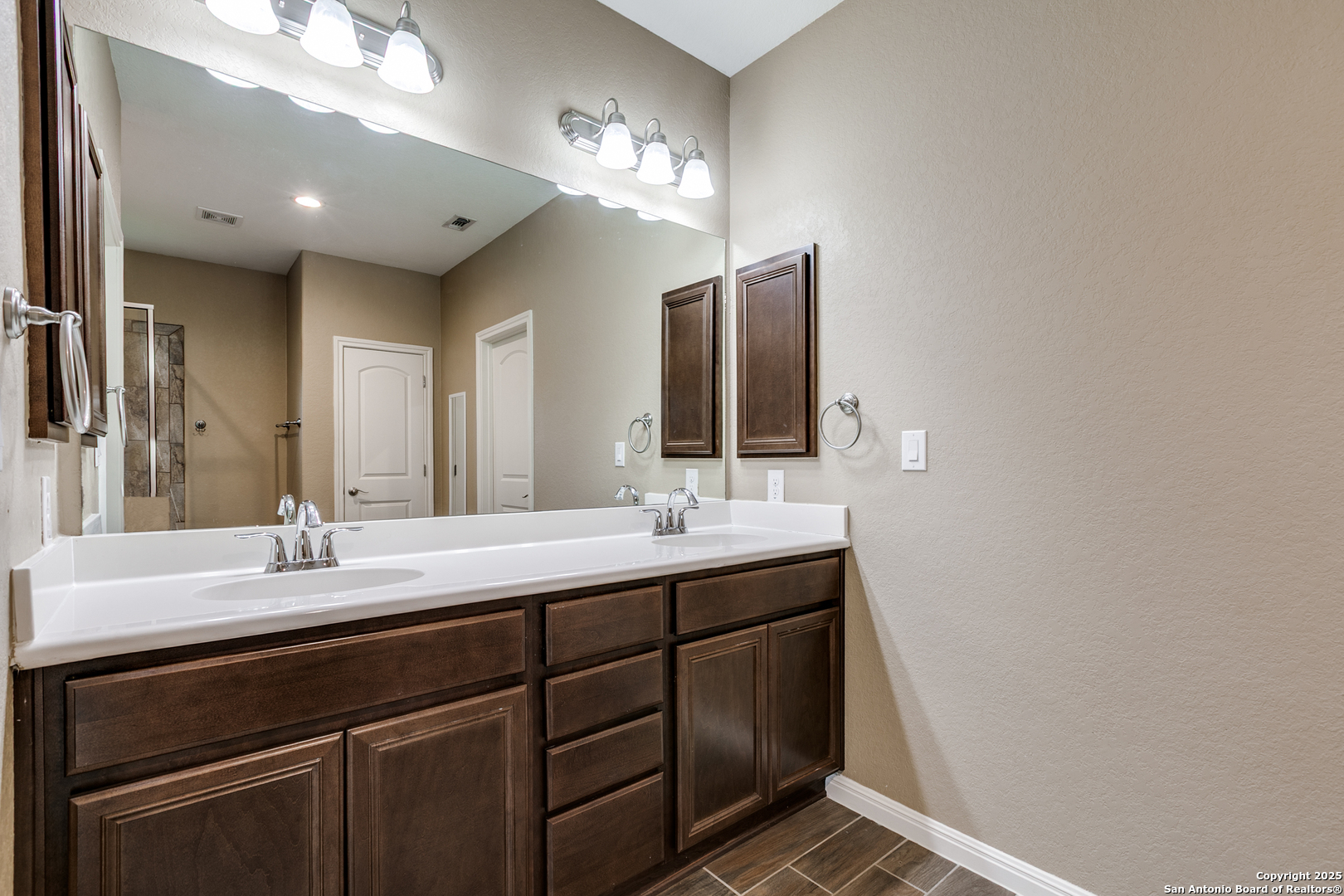 305 Iron Gate Pleasanton, TX 78064 - Photo 19 of 25 a bathroom with a double vanity sink and a mirror