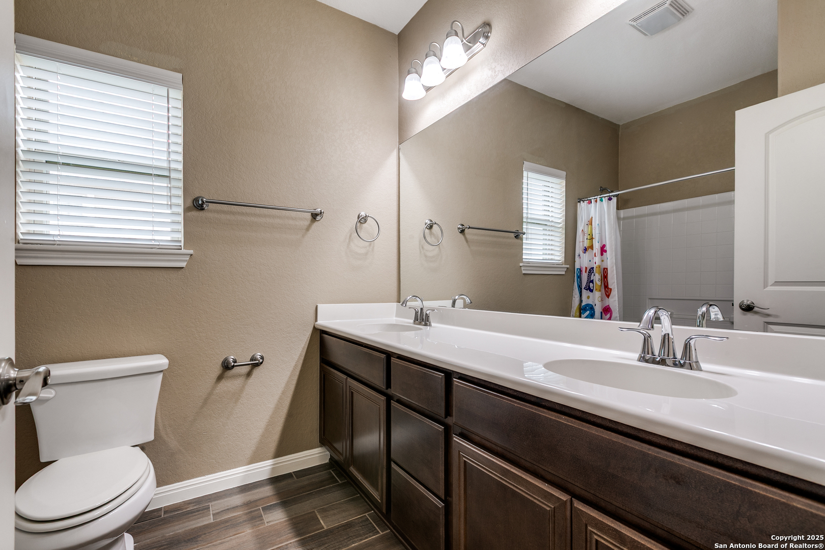 305 Iron Gate Pleasanton, TX 78064 - Photo 20 of 25 a bathroom with a double vanity sink toilet and a mirror