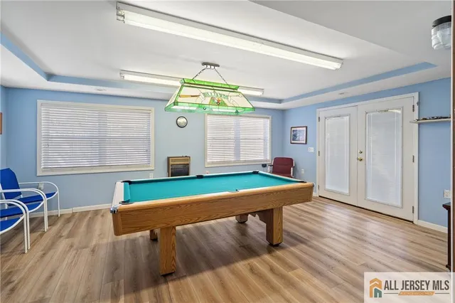 a room with pool table and windows