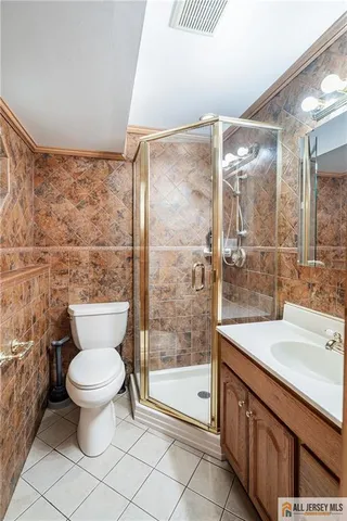 a bathroom with a granite countertop sink a toilet and shower