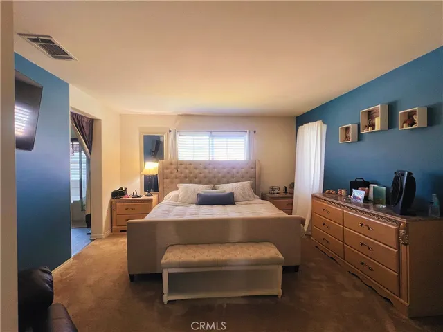 a bedroom with a bed and dresser with mirror