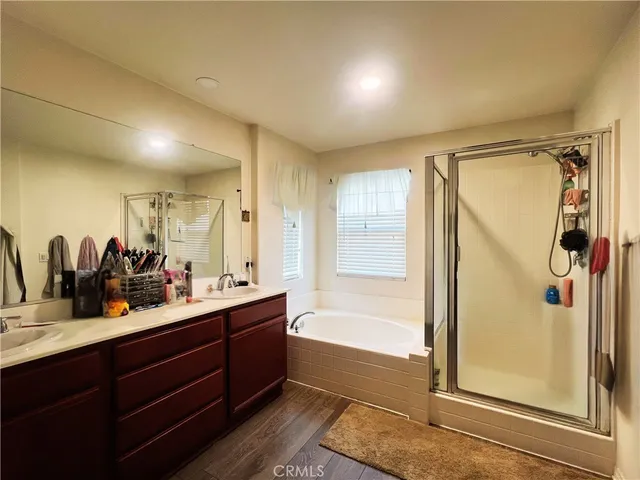 a bathroom with a tub sink shower and mirror