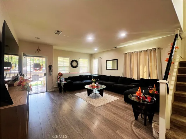 a living room with furniture and a wooden floor