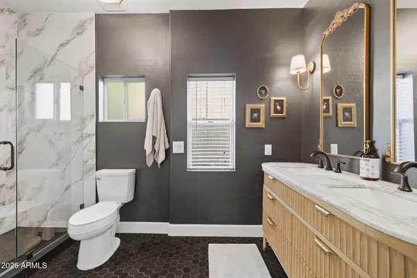a bathroom with a granite countertop sink a toilet and a mirror