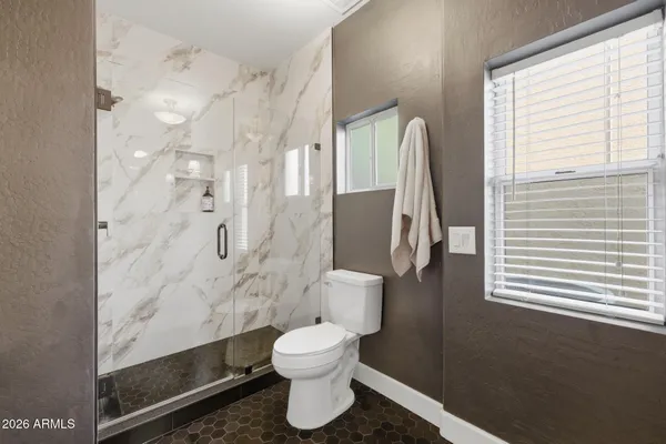 a bathroom with a toilet and a shower