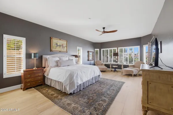 a spacious bedroom with a bed a couch and a large window