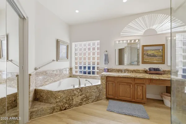 a large spacious bathroom with a tub a double vanity sink a mirror and a shower