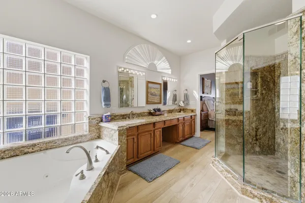 a bathroom with a tub sink shower and mirror