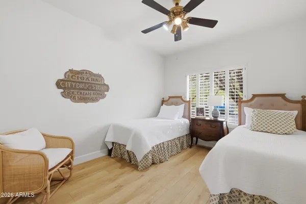 a bedroom with two beds and painting on the wall