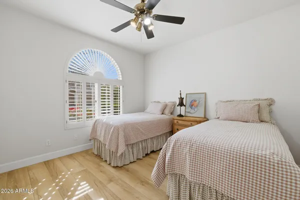 a bedroom with two beds and a chandelier