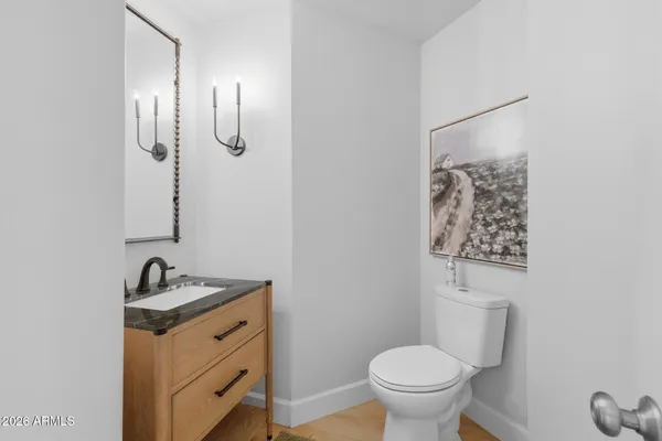 a bathroom with a granite countertop sink toilet and a mirror