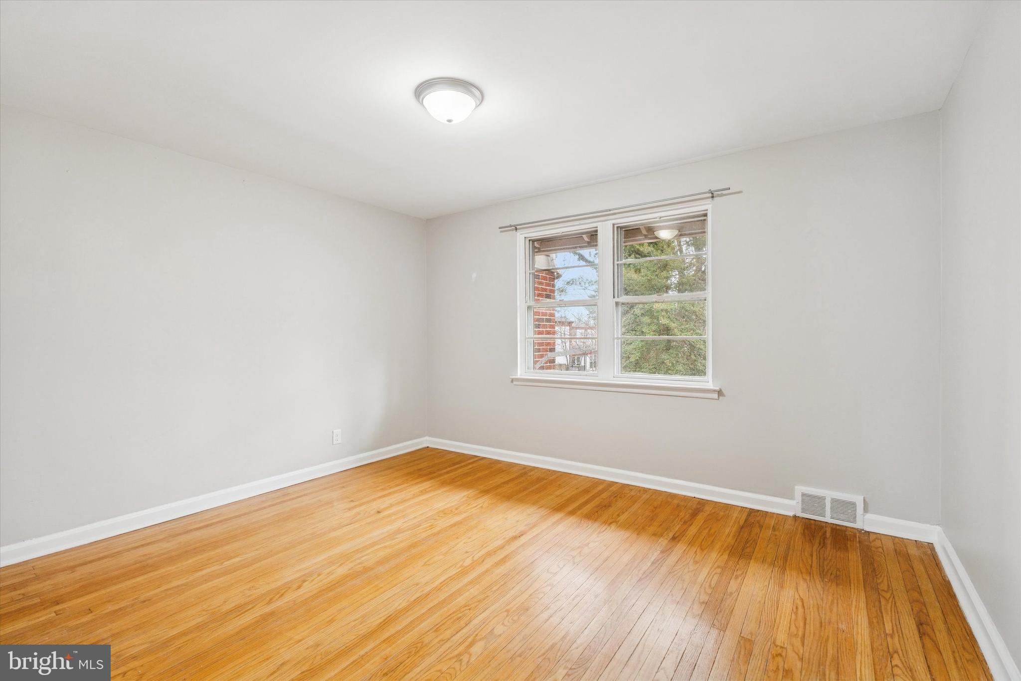 211 Kent Road Wyncote, PA 19095 - Photo 11 of 26 an empty room with wooden floor and windows