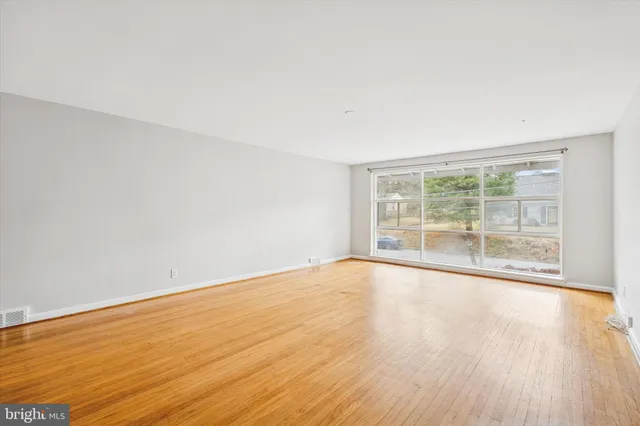 wooden floor in an empty room with a window