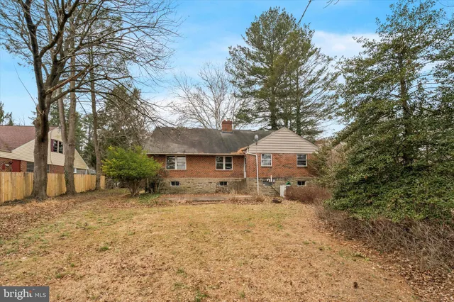 a view of a house with a large tree and a yard