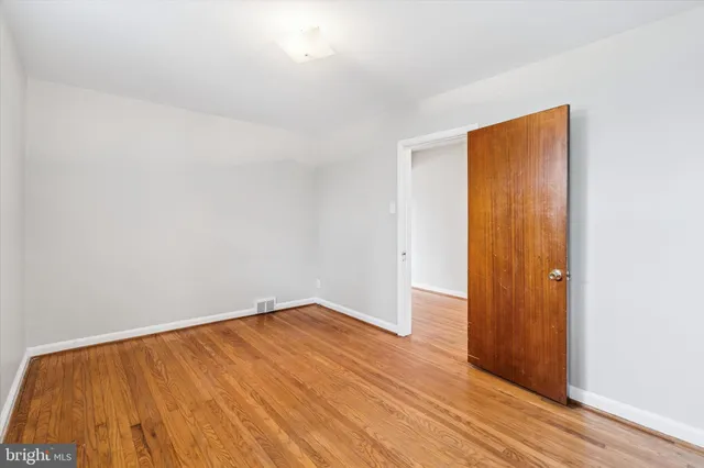 an empty room with wooden floor and closet