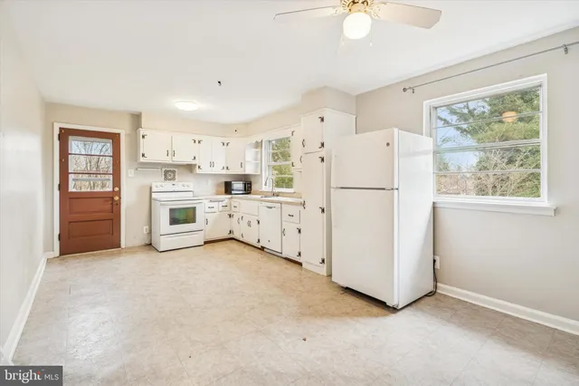 a kitchen with white cabinets and white appliances