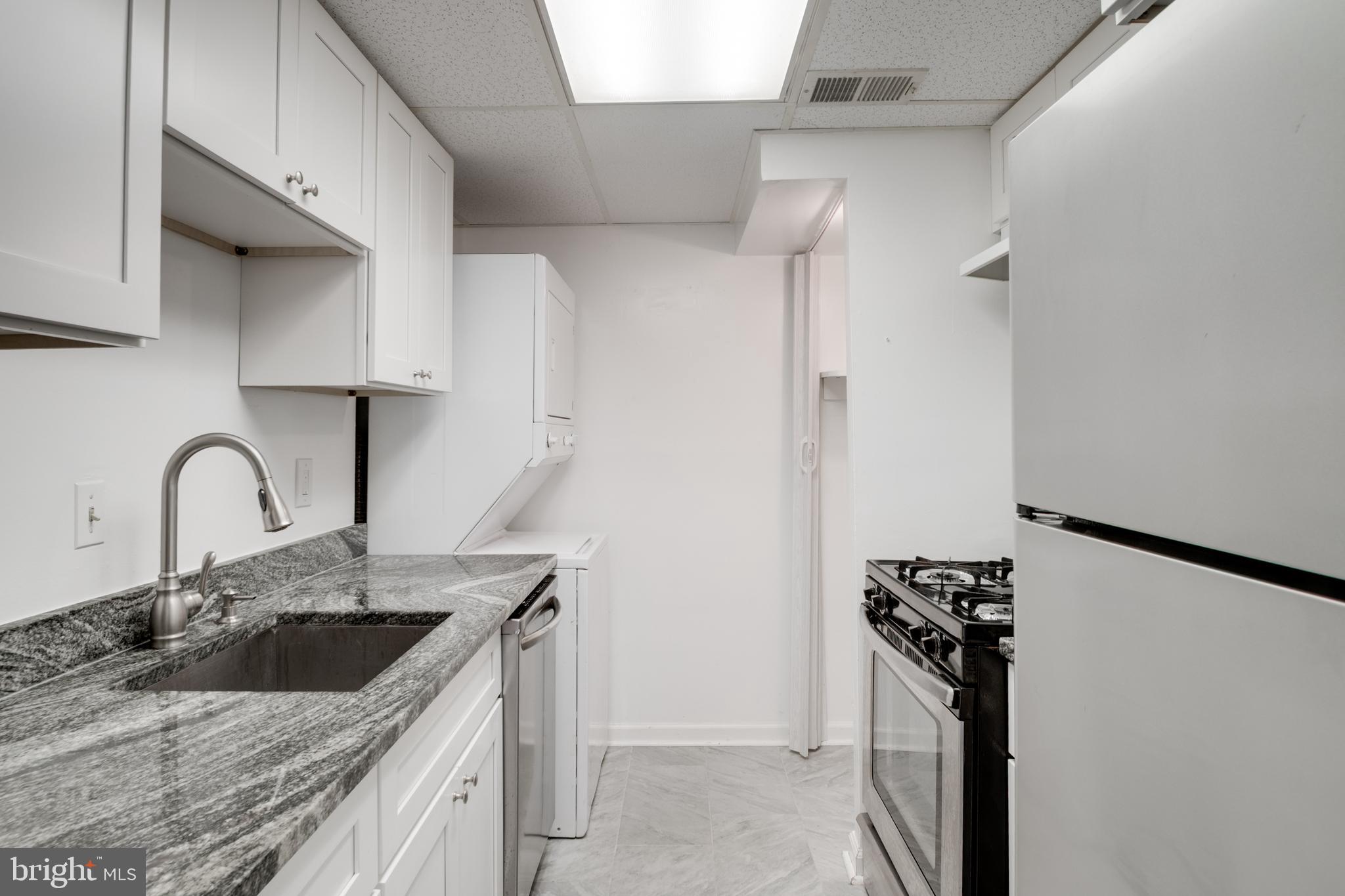 76 King Henry Circle, Unit 76B Baltimore, MD 21237 - Photo 14 of 29 a kitchen with stainless steel appliances granite countertop a sink stove and refrigerator