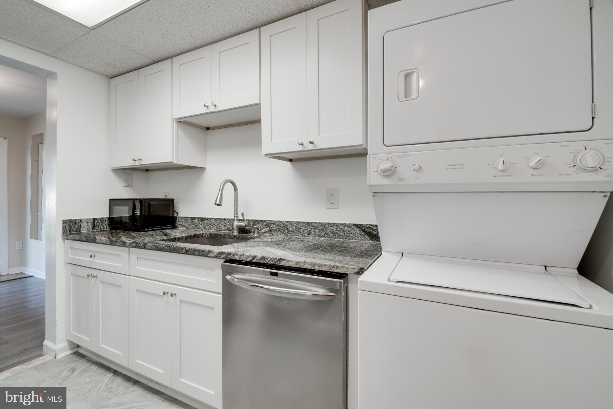 76 King Henry Circle, Unit 76B Baltimore, MD 21237 - Photo 15 of 29 a kitchen with white cabinets and white appliances