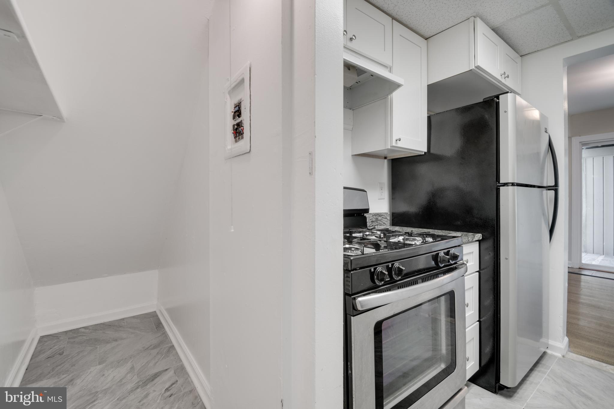 76 King Henry Circle, Unit 76B Baltimore, MD 21237 - Photo 16 of 29 a kitchen with stainless steel appliances a stove a refrigerator and cabinets
