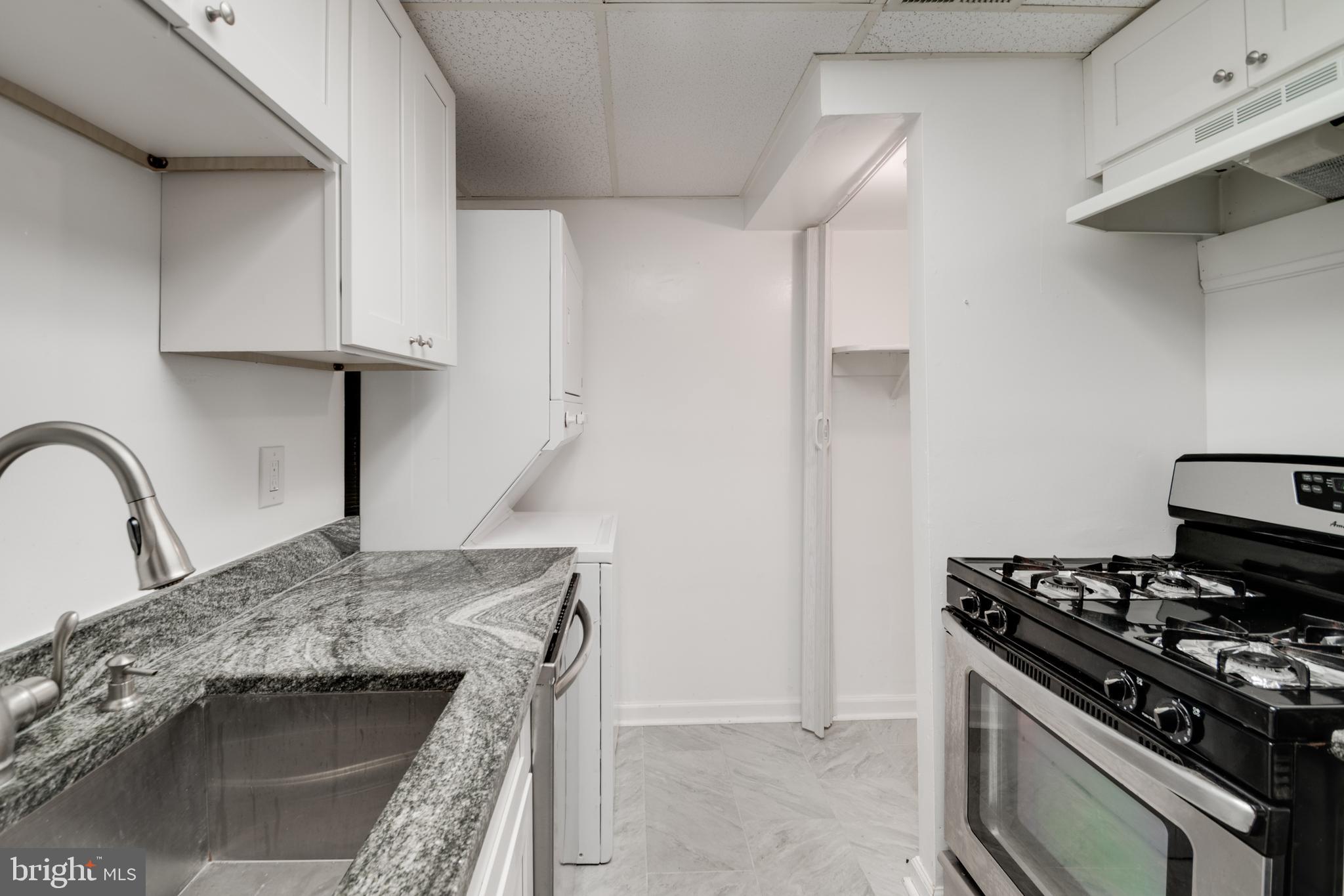 76 King Henry Circle, Unit 76B Baltimore, MD 21237 - Photo 19 of 29 a kitchen with granite countertop a stove and a sink