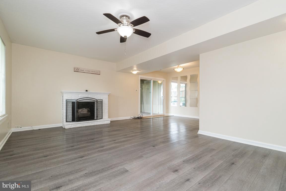 76 King Henry Circle, Unit 76B Baltimore, MD 21237 - Photo 2 of 29 a view of an empty room with wooden floor and a fireplace