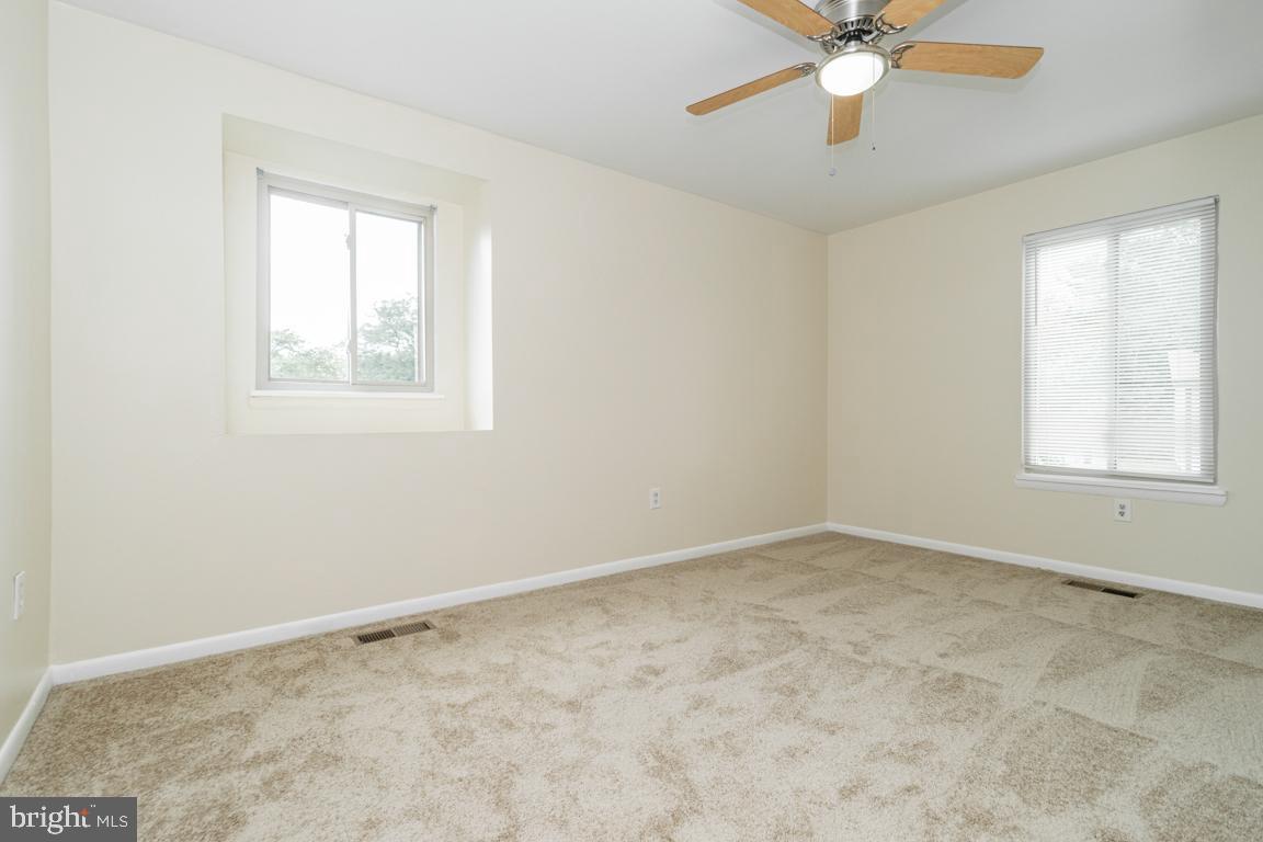 76 King Henry Circle, Unit 76B Baltimore, MD 21237 - Photo 23 of 29 an empty room with a window and a fan