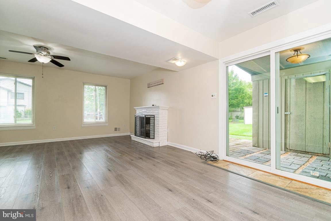 76 King Henry Circle, Unit 76B Baltimore, MD 21237 - Photo 7 of 29 an empty room with wooden floor fan and windows