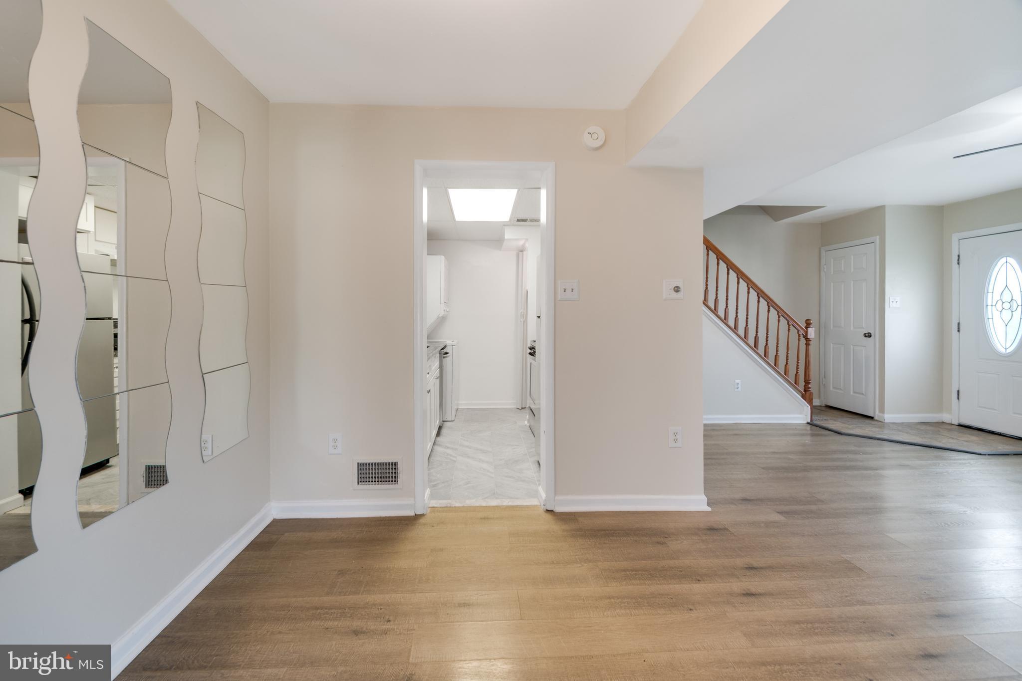 76 King Henry Circle, Unit 76B Baltimore, MD 21237 - Photo 9 of 29 a view of an empty room with wooden floor and a fireplace