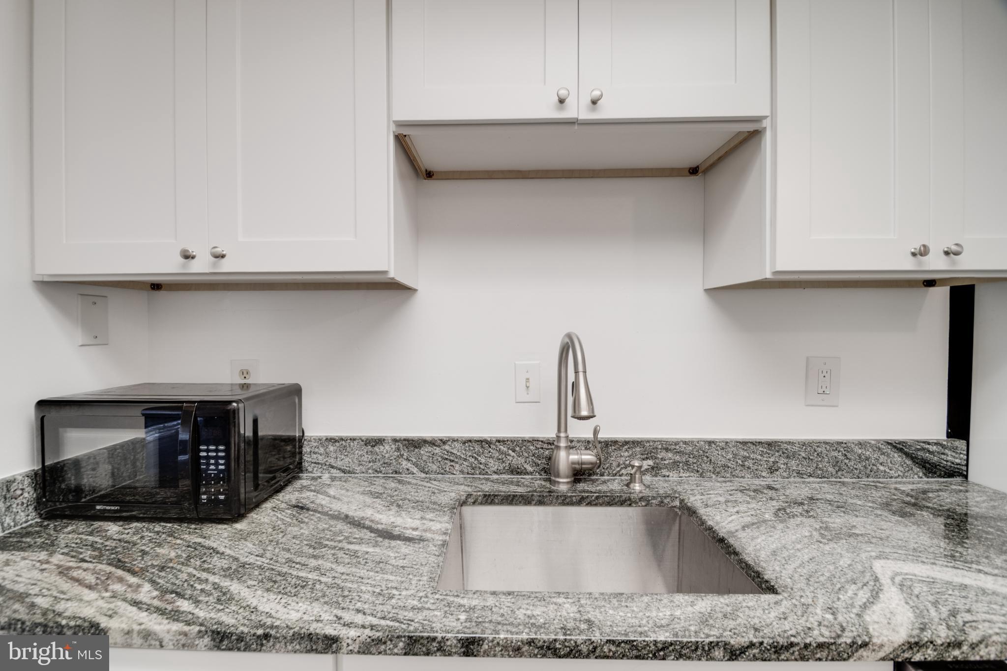 76 King Henry Circle, Unit 76B Baltimore, MD 21237 - Photo 10 of 29 a kitchen with granite countertop a sink and a stove
