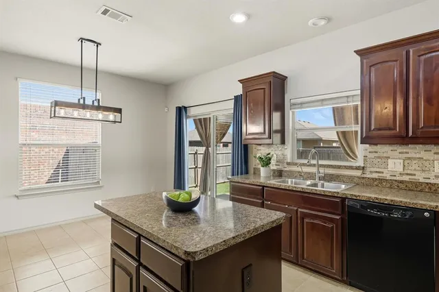a kitchen with stainless steel appliances granite countertop a sink a microwave cabinets and wooden floor