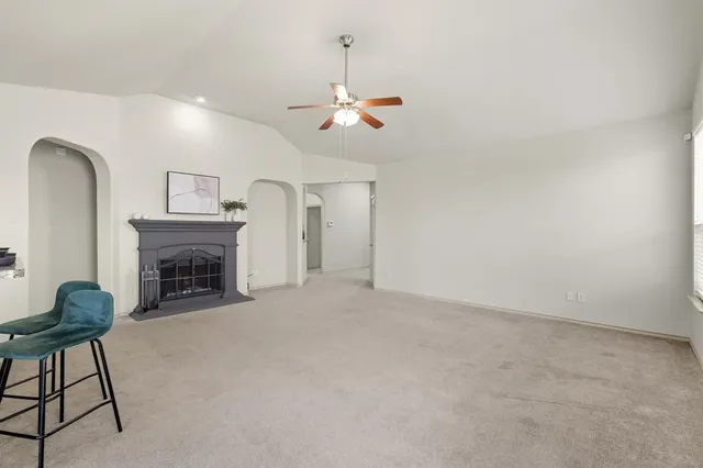 a view of a livingroom with a fireplace and chandelier fan
