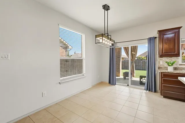 a view of an empty room with window and cabinet