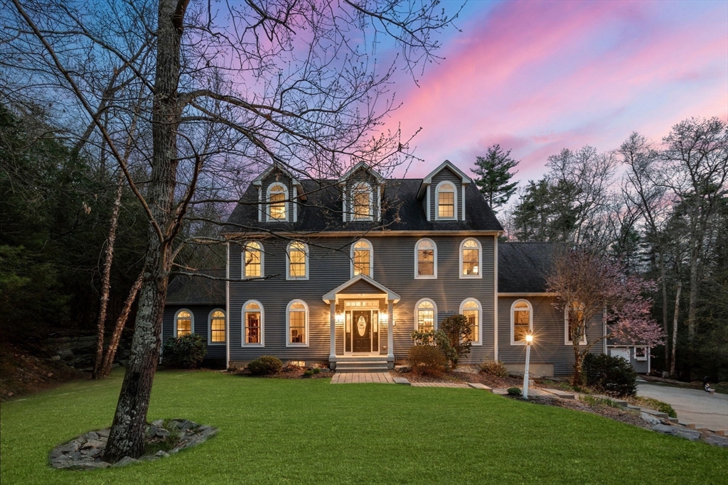 a front view of a house with a tree in front of it