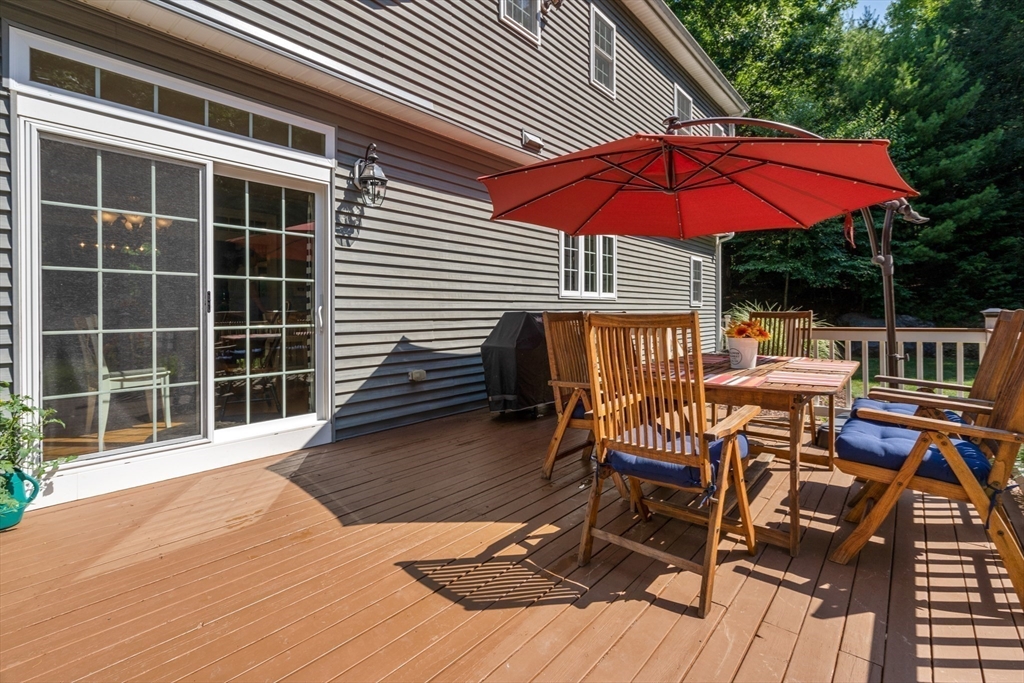 400 New Boston Road Sturbridge, MA 01566 - Photo 38 of 42 a patio with a table and chairs under an umbrella